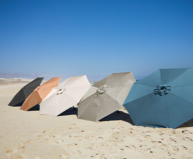 AGGER parasoller i olika färger på stranden 