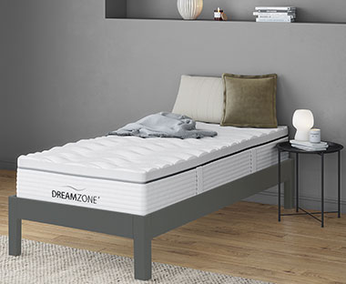 GOLD S100 säng i ett sovrum med sängbord bredvid