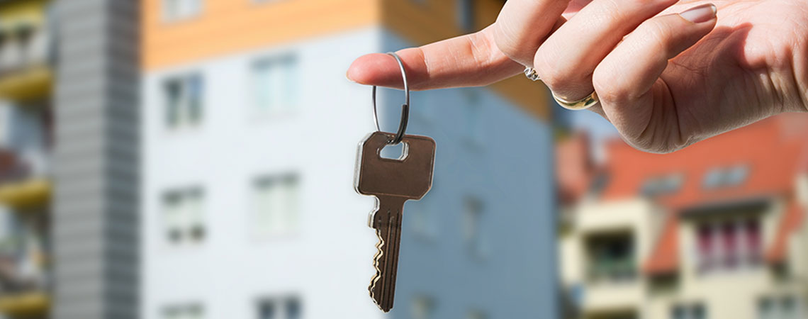 Kvinna hyr ut sin bostad, håller i en nyckel 