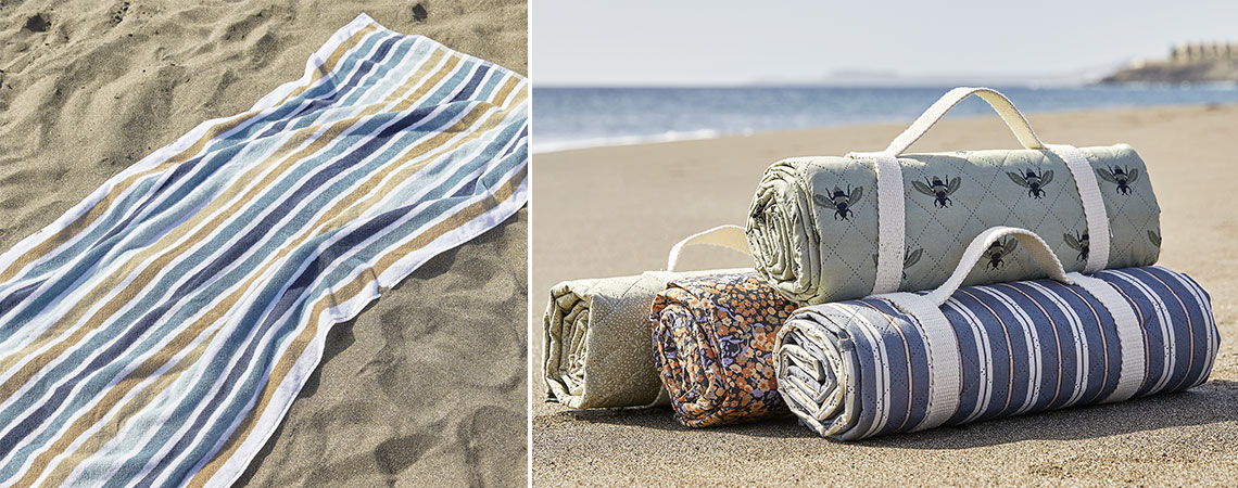 Strandhandduk och vattentäta picknickfiltar på en strand