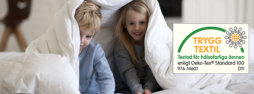 Två barn under ett täcke som är textil certifierat av STANDARD 100 by OEKO-TEX®