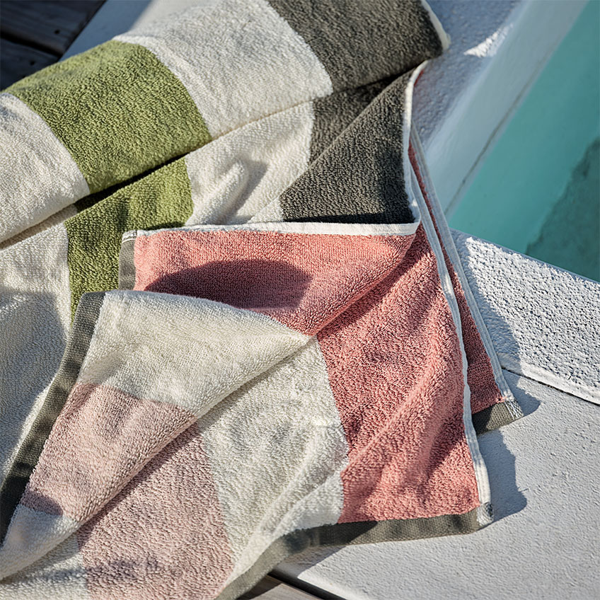 Striped beach towel in red, white, grey, pink, and salmon colour