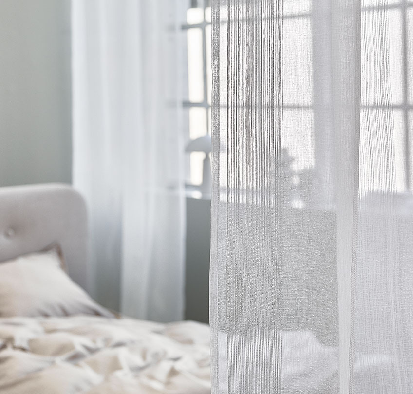 Vita gardiner används för att separera en sovplats från ett vardagsrum