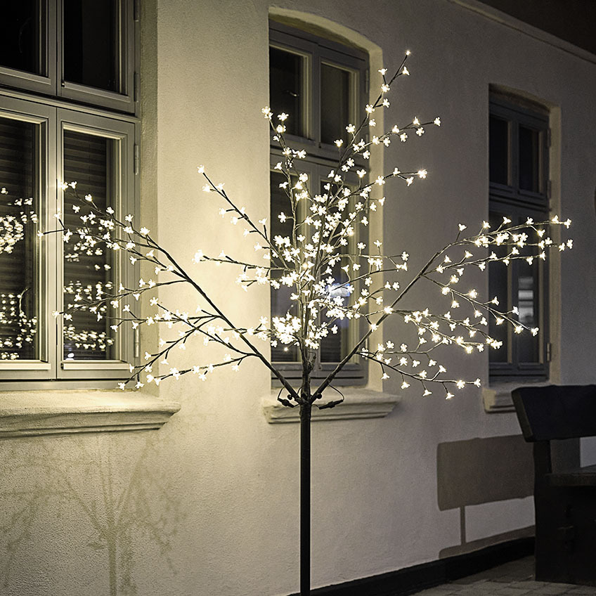 Stort LED-ljusträd som lyser upp hus