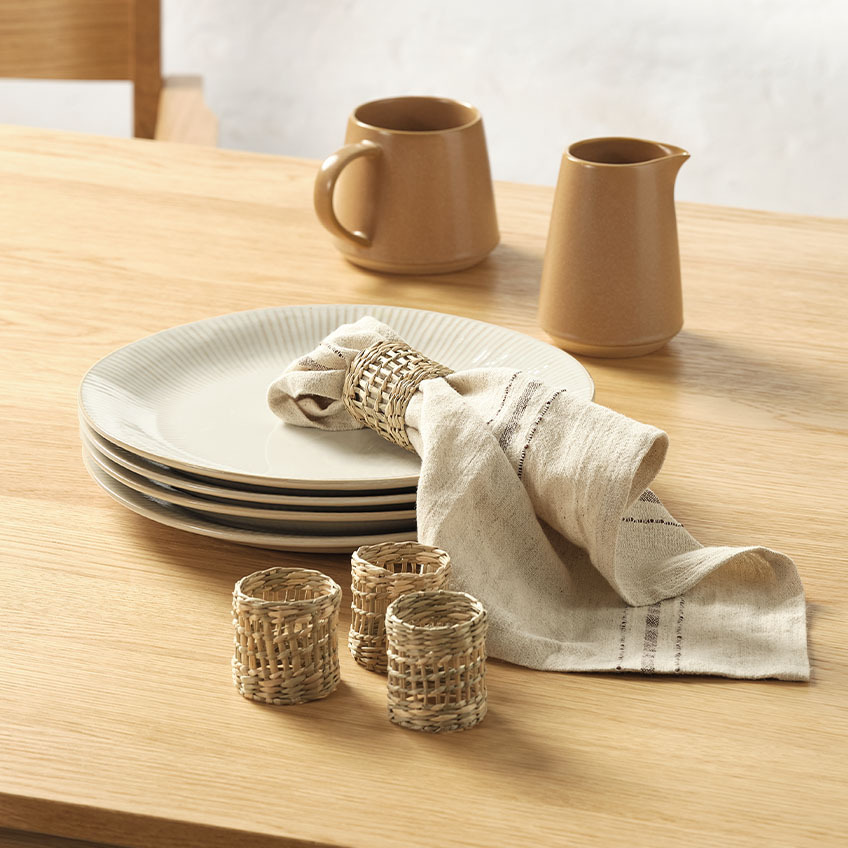 Mugg, servett och servettringar på ett matbord