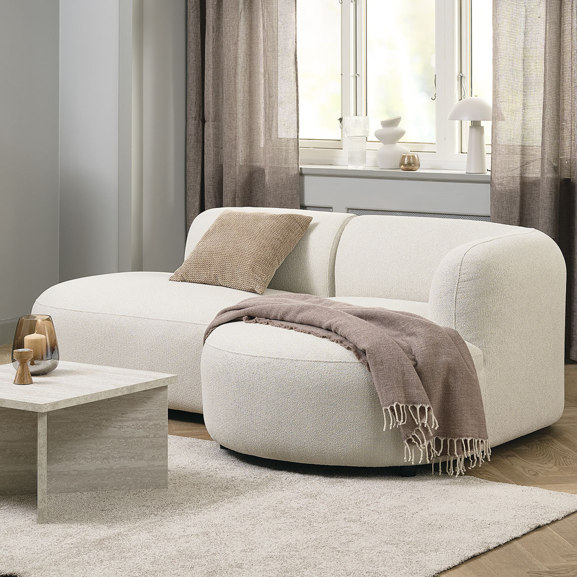 Beige 2-sits soffa med runda och organiska former