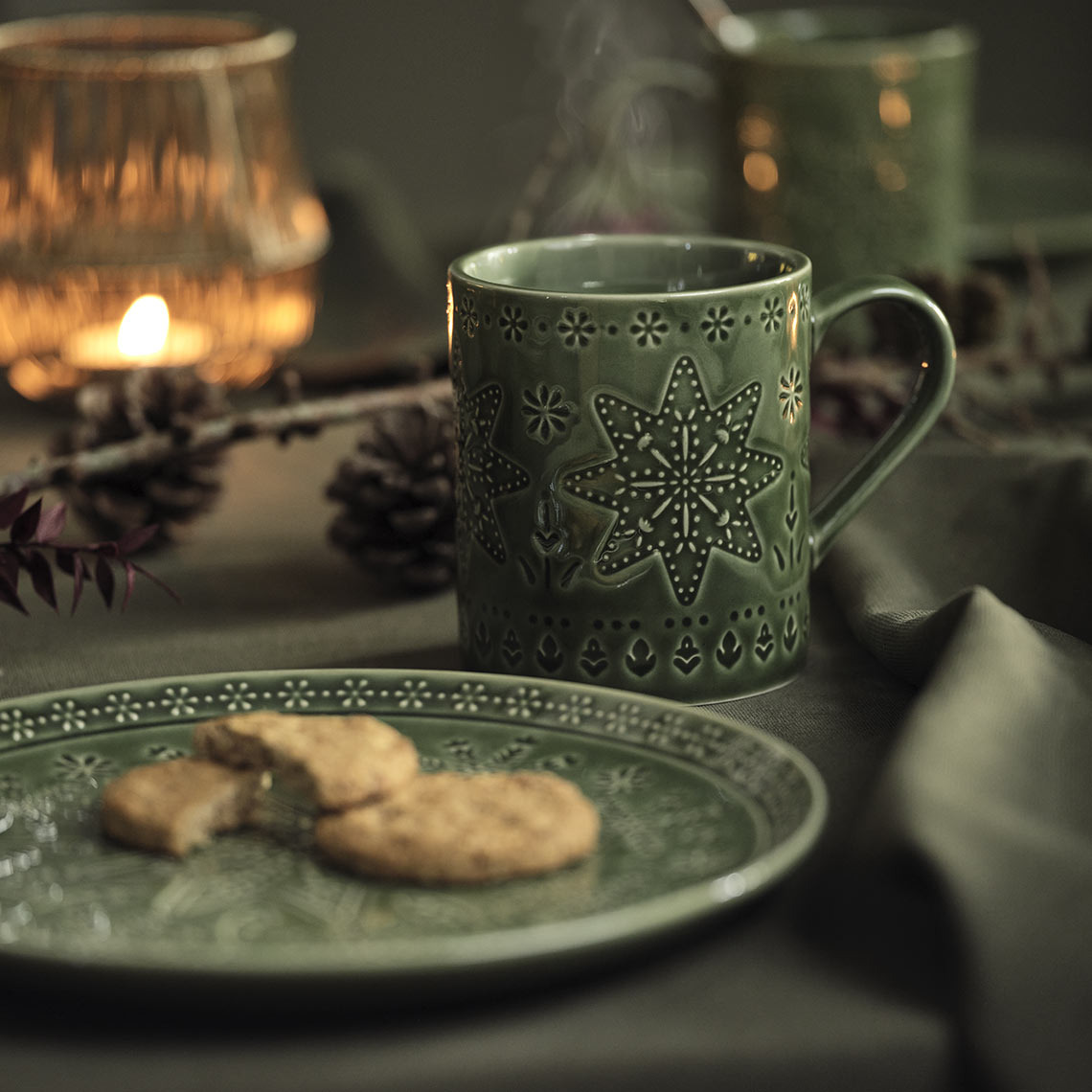 Grön julplatta och mugg på ett julbord 