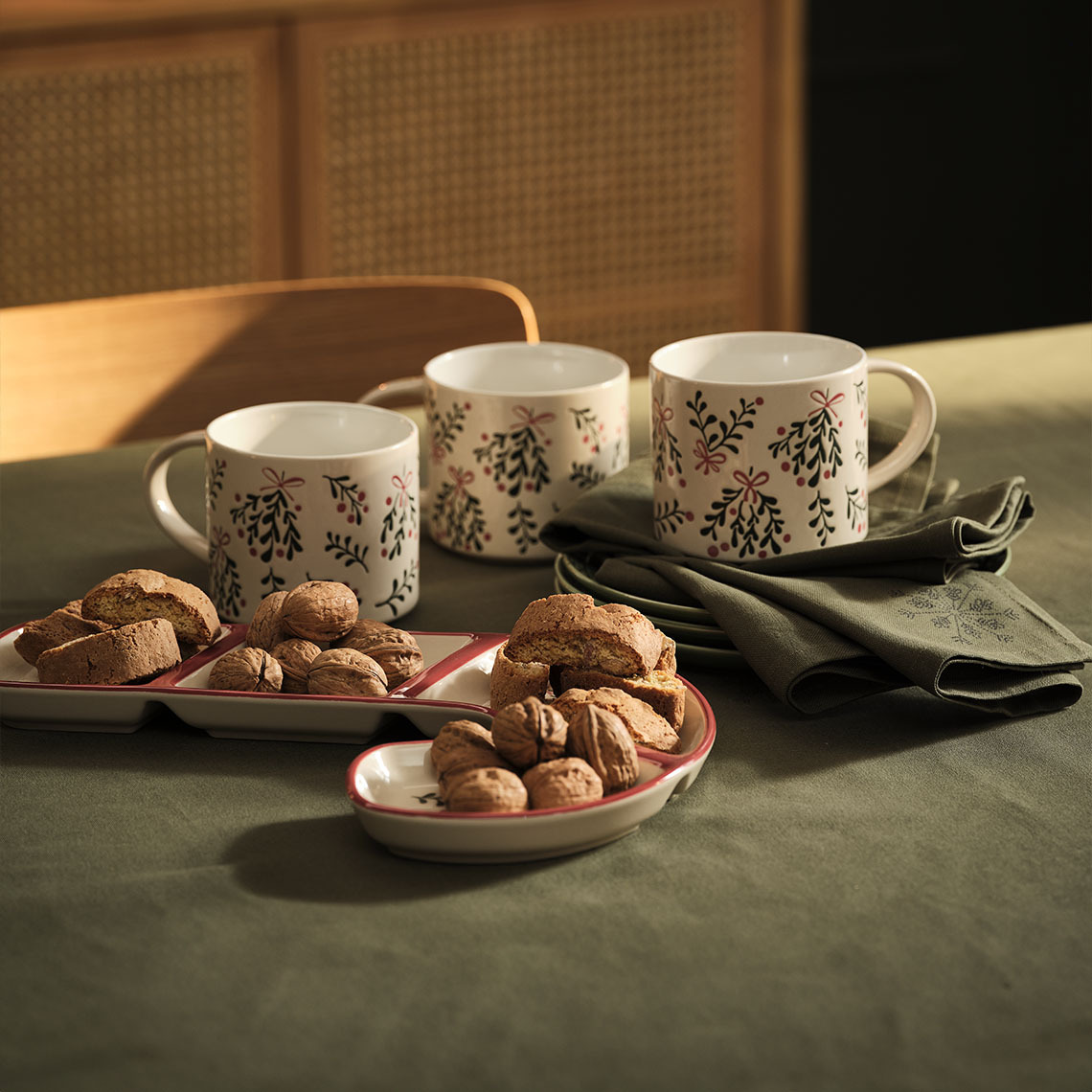 Julmuggar, skål och jultygservetter på ett bord