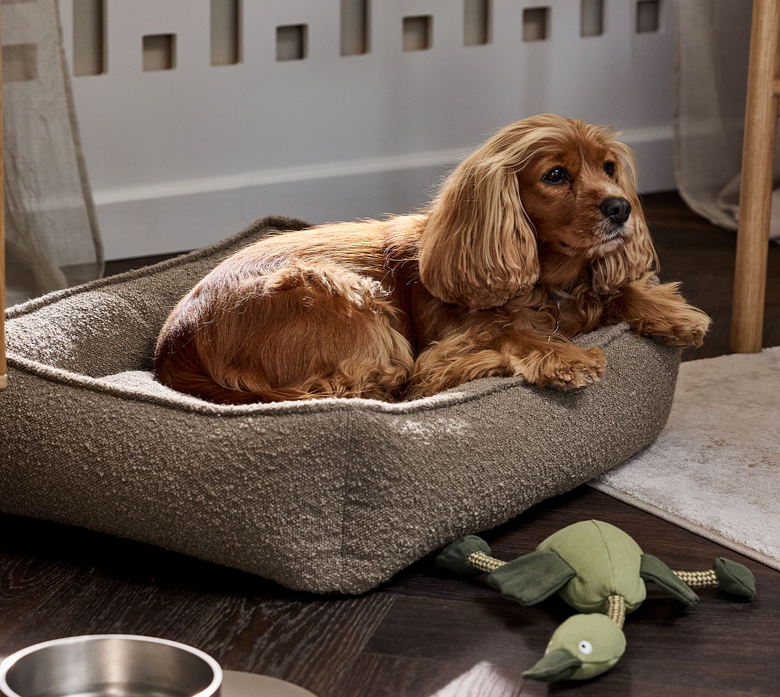 Turmalin hundbädd, finns i två storlekar Bouclé-liknande hundbädd i ljusbrungrön färg med bruna hund- och hundleksaker