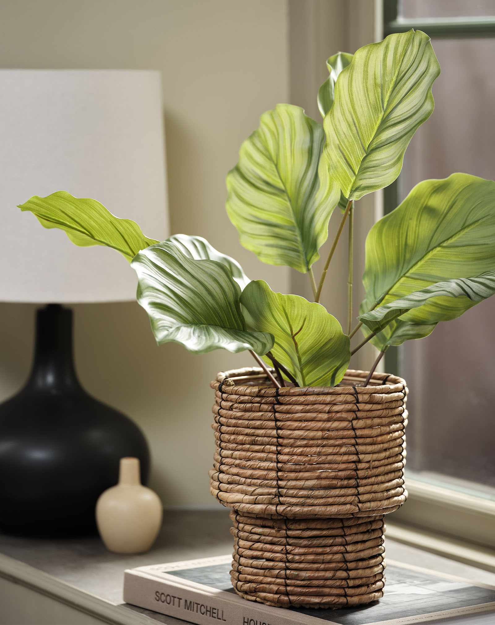 Konstgjord växt av en calathea i en vävd kruka