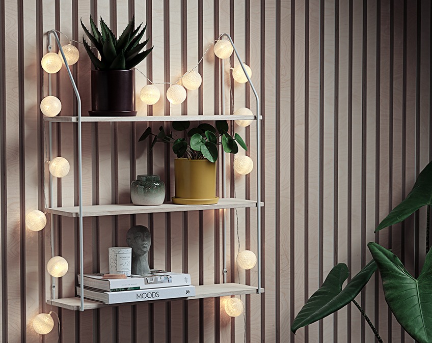 Light string draped around a wall shelf Light string draped around a wall shelf