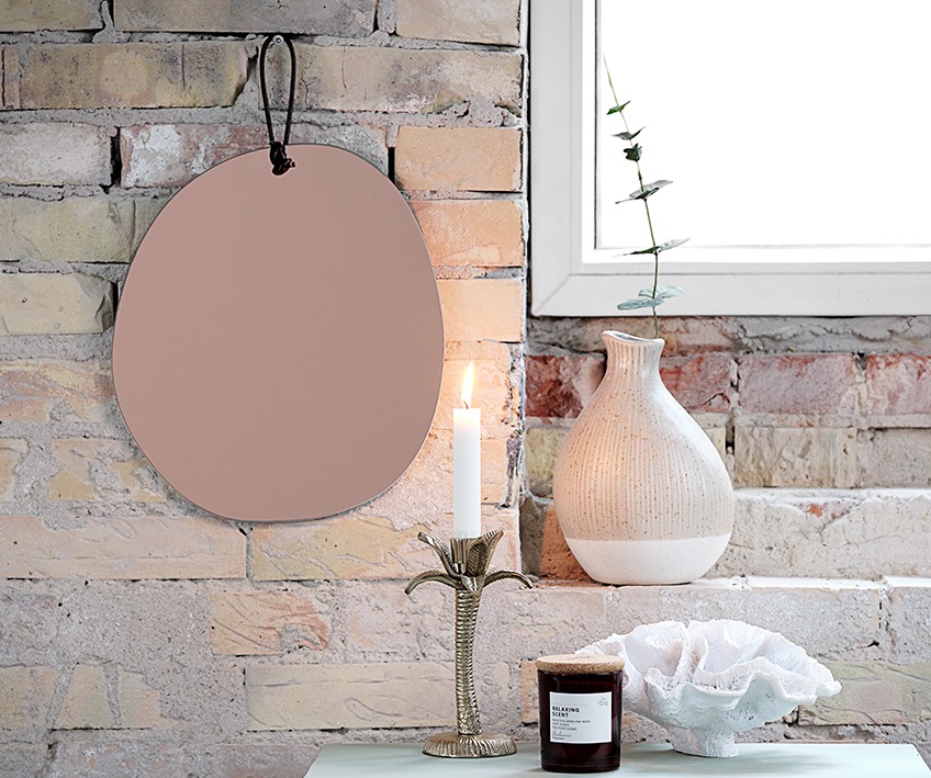 Wall mirror, candle stick, vase, scented candle and ornament by window 