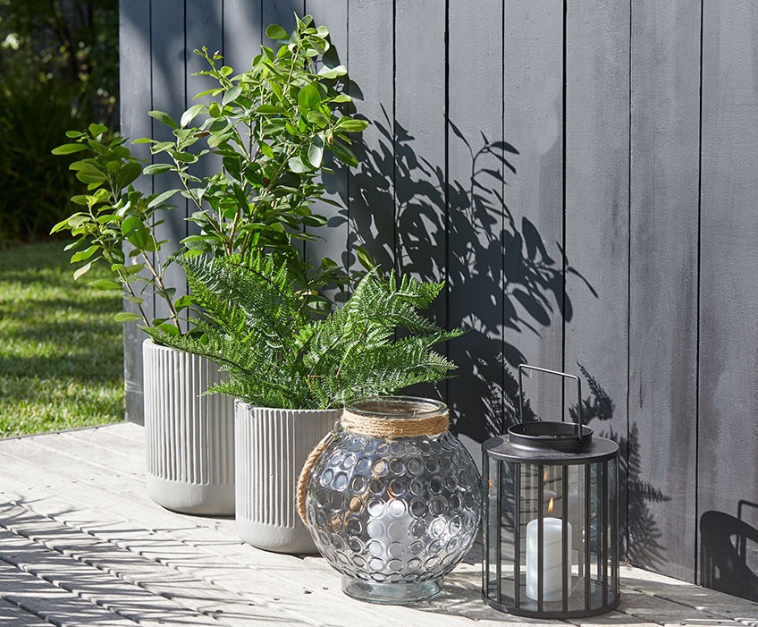 Small and large ILDROVFLUE garden pots and MYRSANGER and GRANMEIS lanterns Small and large garden pots and two lanterns on a sunny patio