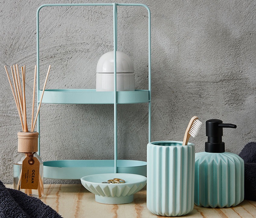 Bathroom shelving unit with storage jar, toothbrush holder, soap dispenser and scented oil in a bathroom