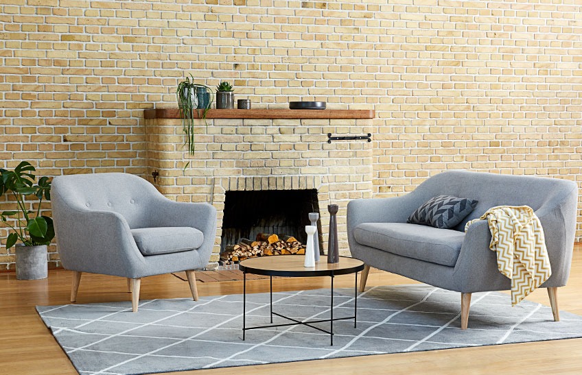 A living room with a grey sofa, a grey armchair and a coffee table