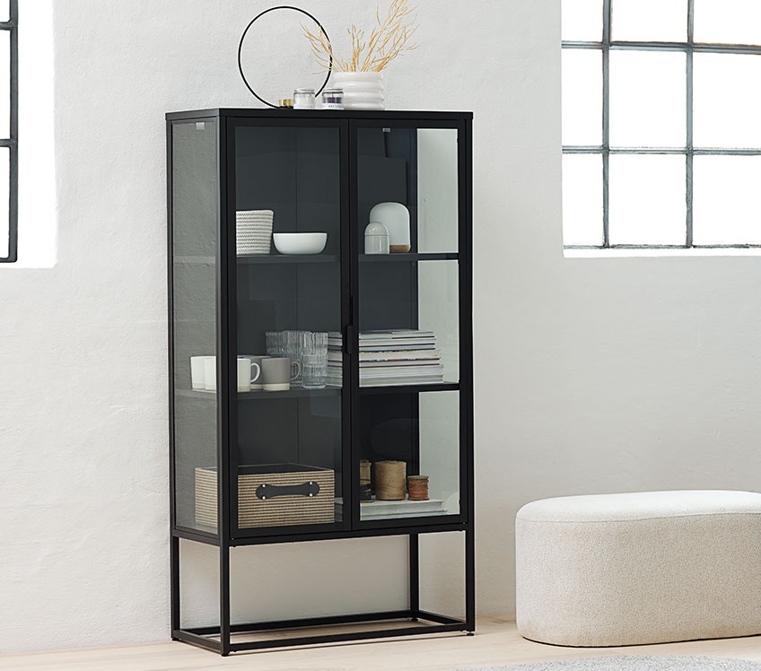 VIRUM Vitrinskåp med FREJ jutekorg, CLAES glas och FLORIAN bordslampa Svart vitrinskåp med glas, koppar, böcker och förvaringskorgar