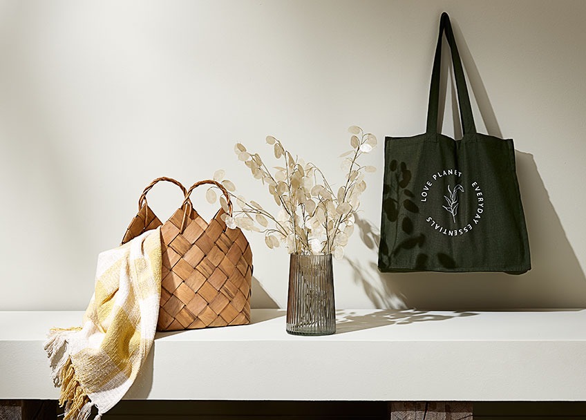 Basket with a throw, vase with artificial flowers and a shopping bag 