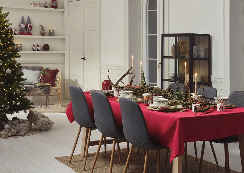Matbord dekorerat för jul och julgran med presenter