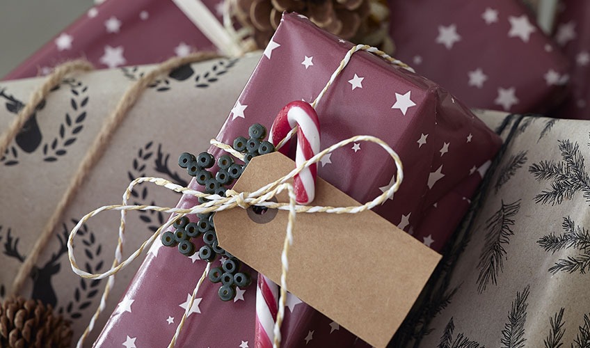 Julklapp inslagen i papper och dekorerad med godis och pärlor