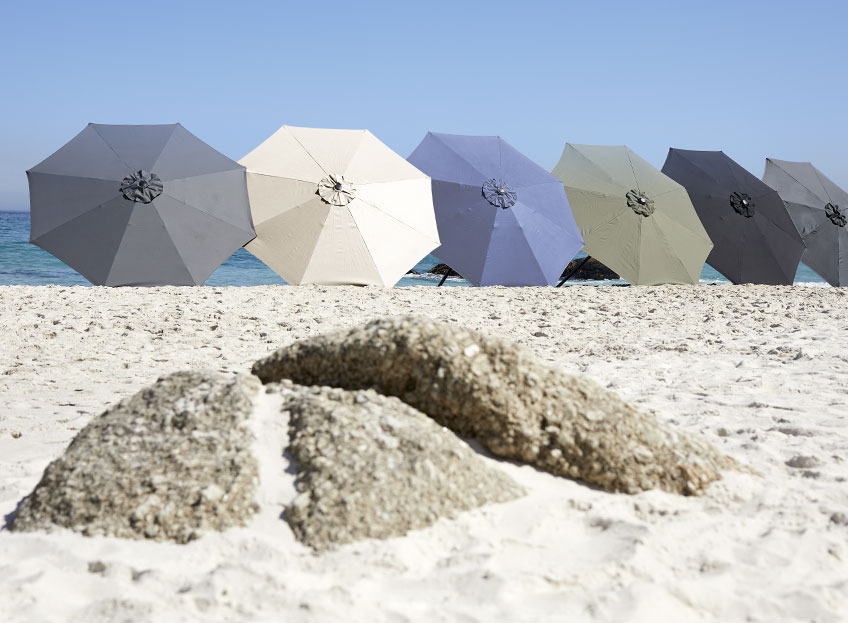 Parasoller i fler olika färger på stranden 