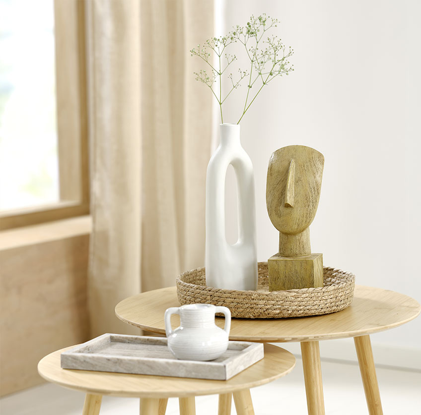 Marmorbricka med vit värmeljushållare och sjögräsbricka med vit vas och skulptur