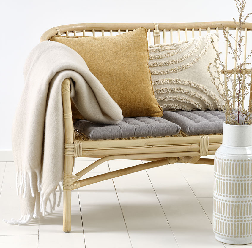 LISELEJE soffa med beige GRAVMYRT kudde, gul HORNFIOL kudde och TUSENFRYD pläd Rottingsoffa med beige och gula kuddar och beige pläd