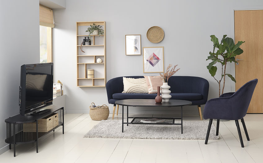 Vardagsrum med en svart TV-bänk, soffa, soffbord och fåtölj