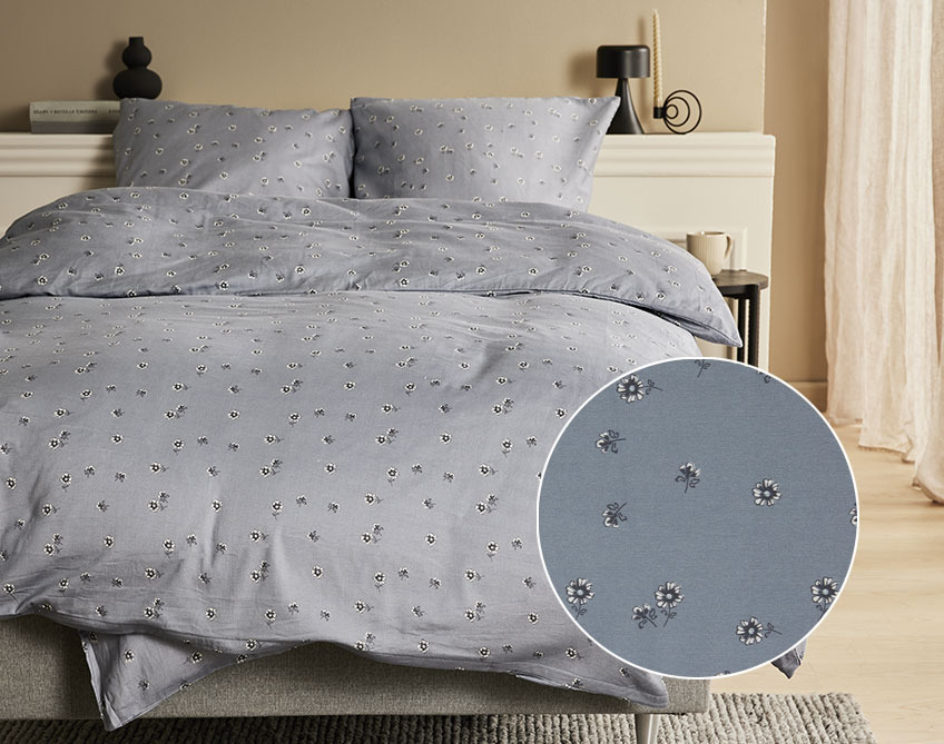 Sängkläder från GERD är 100 % satin Säng med satängsängkläder med små blommor på en mörkgrå bakgrund