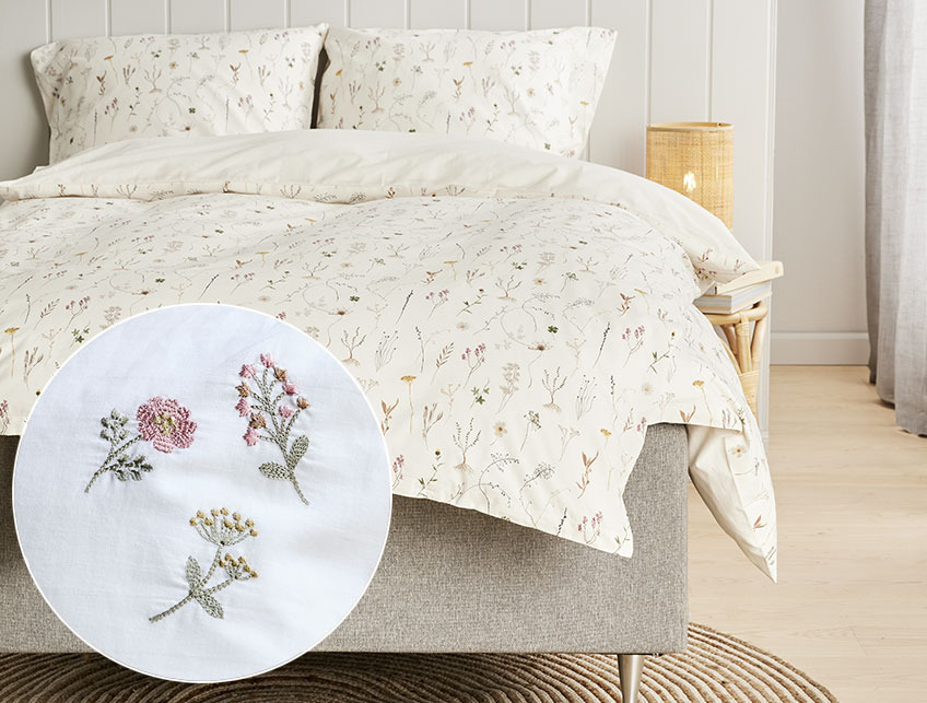 SUSSI sänglinne med inlägg av MAJ örngott Blommigt sänglinne i ett ljust sovrum