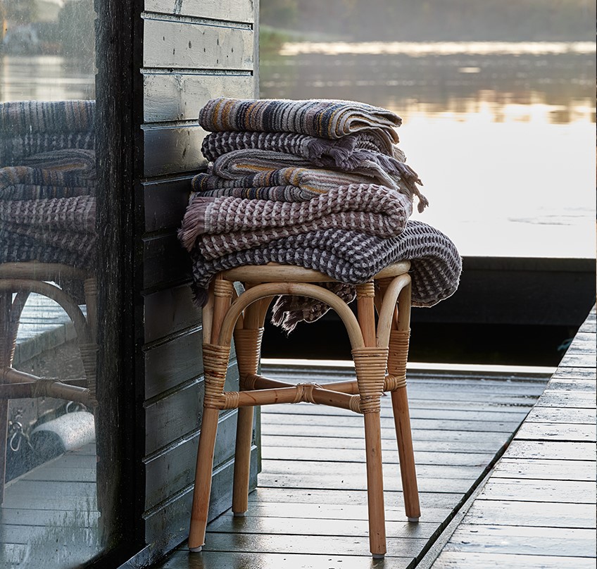 Hand towels, guest towels and striped towels on a stool by a lake