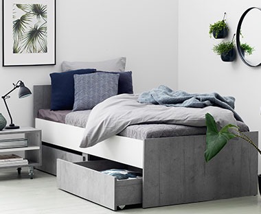 Sovbädd med förvaringslådor under sängen i betong-look